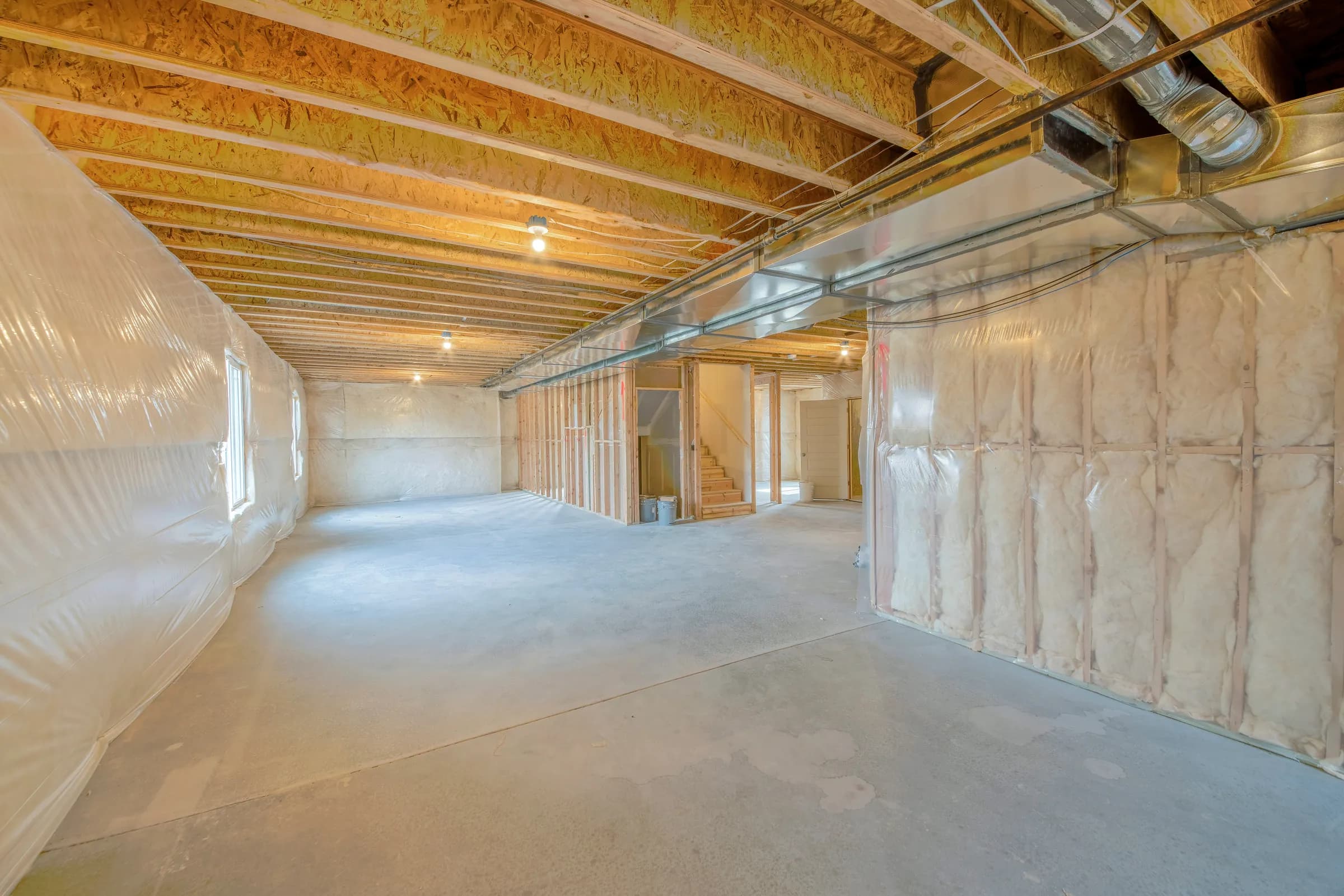 Basement walls insulated with fiberglass batts and a vapour barrier in a newly built home